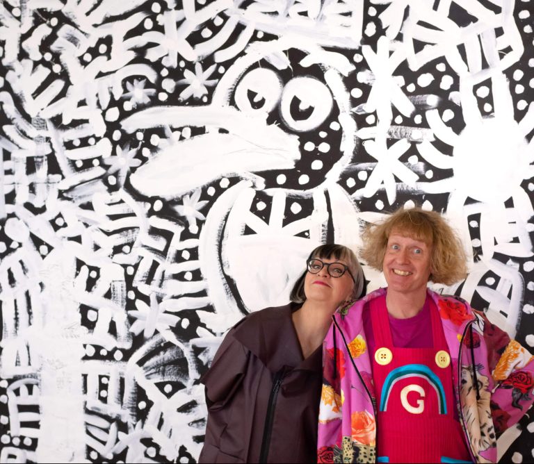 Grayson Perry and Philippa Perry in front of picture at Grayson's Art Club at Bristol Museum